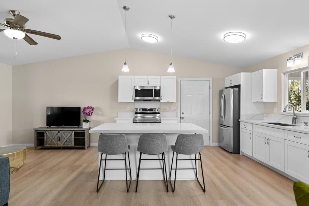a kitchen with stainless steel appliances a stove a refrigerator and a dining table