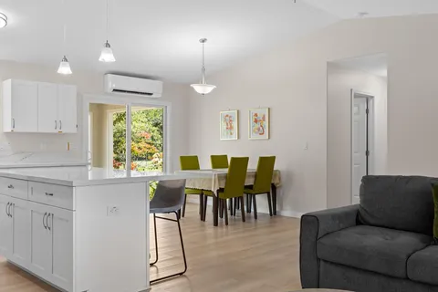 a kitchen with stainless steel appliances kitchen island granite countertop a stove a sink a microwave a dining table and chairs