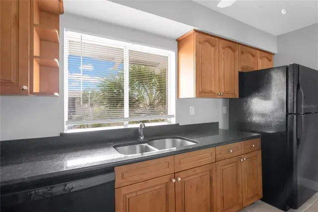 a kitchen with stainless steel appliances granite countertop a sink and a refrigerator
