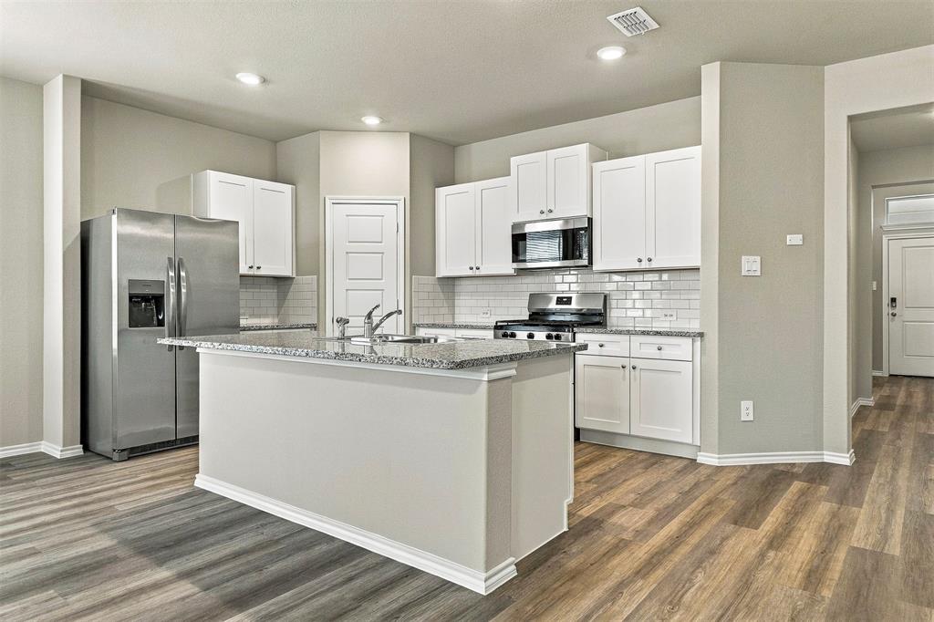 15932 Stableford Road Justin, TX 76247 - Photo 8 of 35 Kitchen featuring an island with a light-toned countertop, stainless steel appliances, white cabinetry, subway tile backsplash, and recessed lighting
