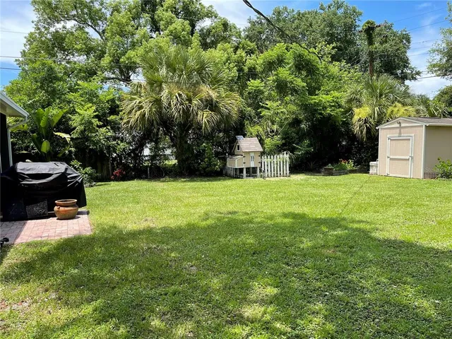 a view of a backyard with a garden and entertaining space
