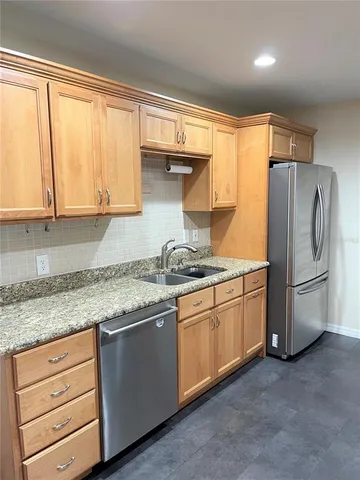 a kitchen with granite countertop cabinets stainless steel appliances and a window