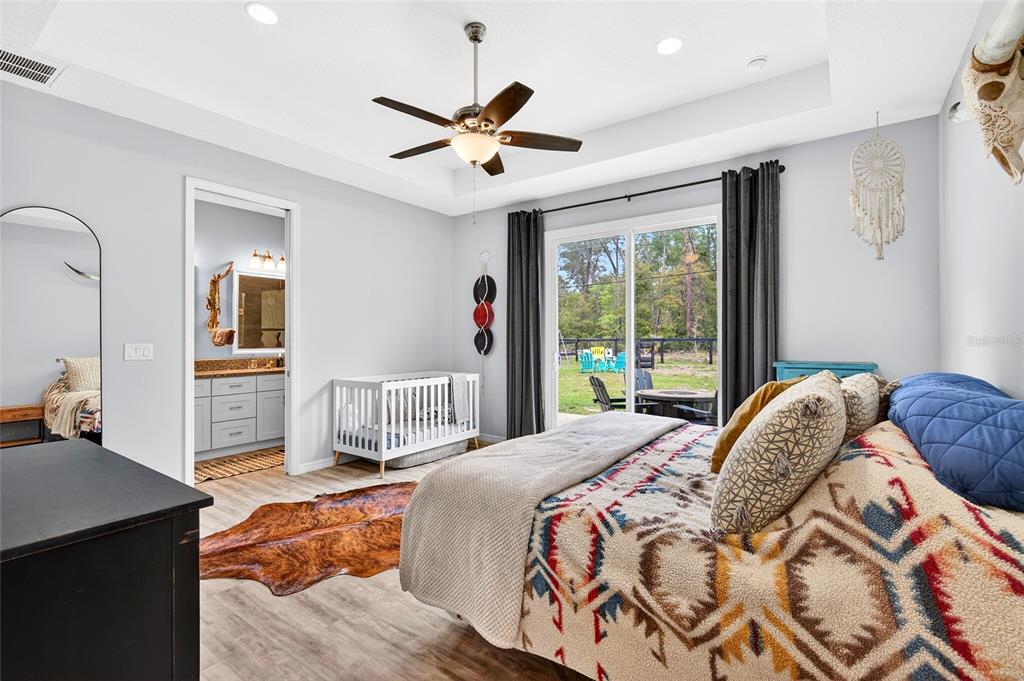 3699 Southwest 177th Lane Road Ocala, FL 34473 - Photo 12 of 26 a bedroom with a large bed and a chandelier