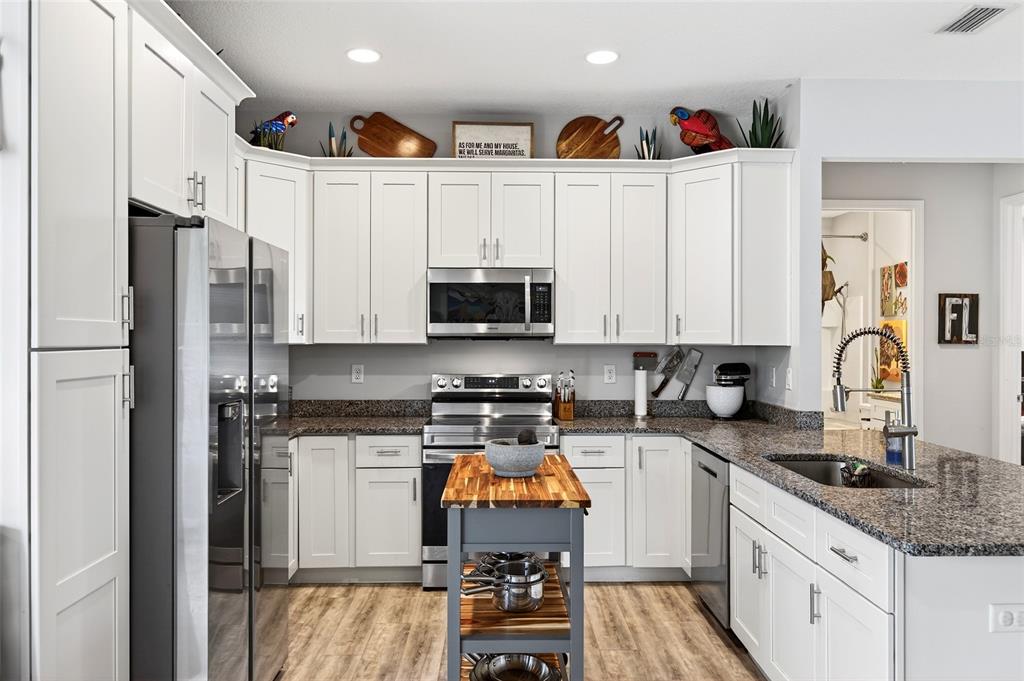3699 Southwest 177th Lane Road Ocala, FL 34473 - Photo 9 of 26 a kitchen with stainless steel appliances granite countertop a stove top oven a sink and cabinets