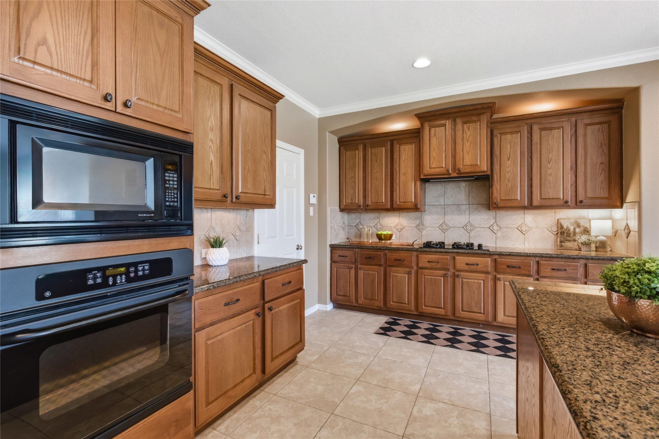20722 Windrose Bend Drive Spring, TX 77379 - Photo 16 of 50 Such an inviting kitchen, ideal for entertaining, boasting a separate gas cooktop, elegant cabinet lighting, crown molding, a deep stainless sink with reverse osmosis water filtration, and a versatile breakfast bar.