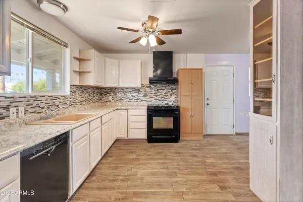 a kitchen with stainless steel appliances granite countertop a sink and a refrigerator