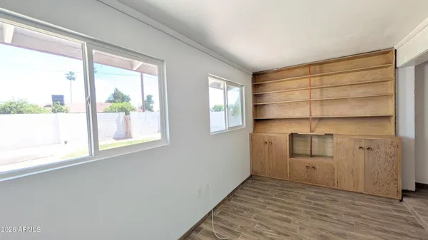 a room with a white bed and cabinets