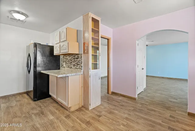 a view of kitchen with stainless steel appliances granite countertop a refrigerator and a stove