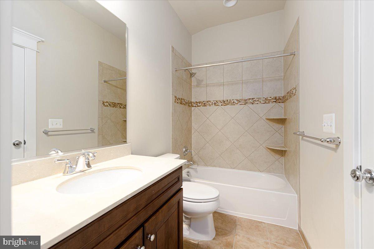 8104 Old Georgetown Road Bethesda, MD 20814 - Photo 22 of 28 a bathroom with a granite countertop sink toilet and shower