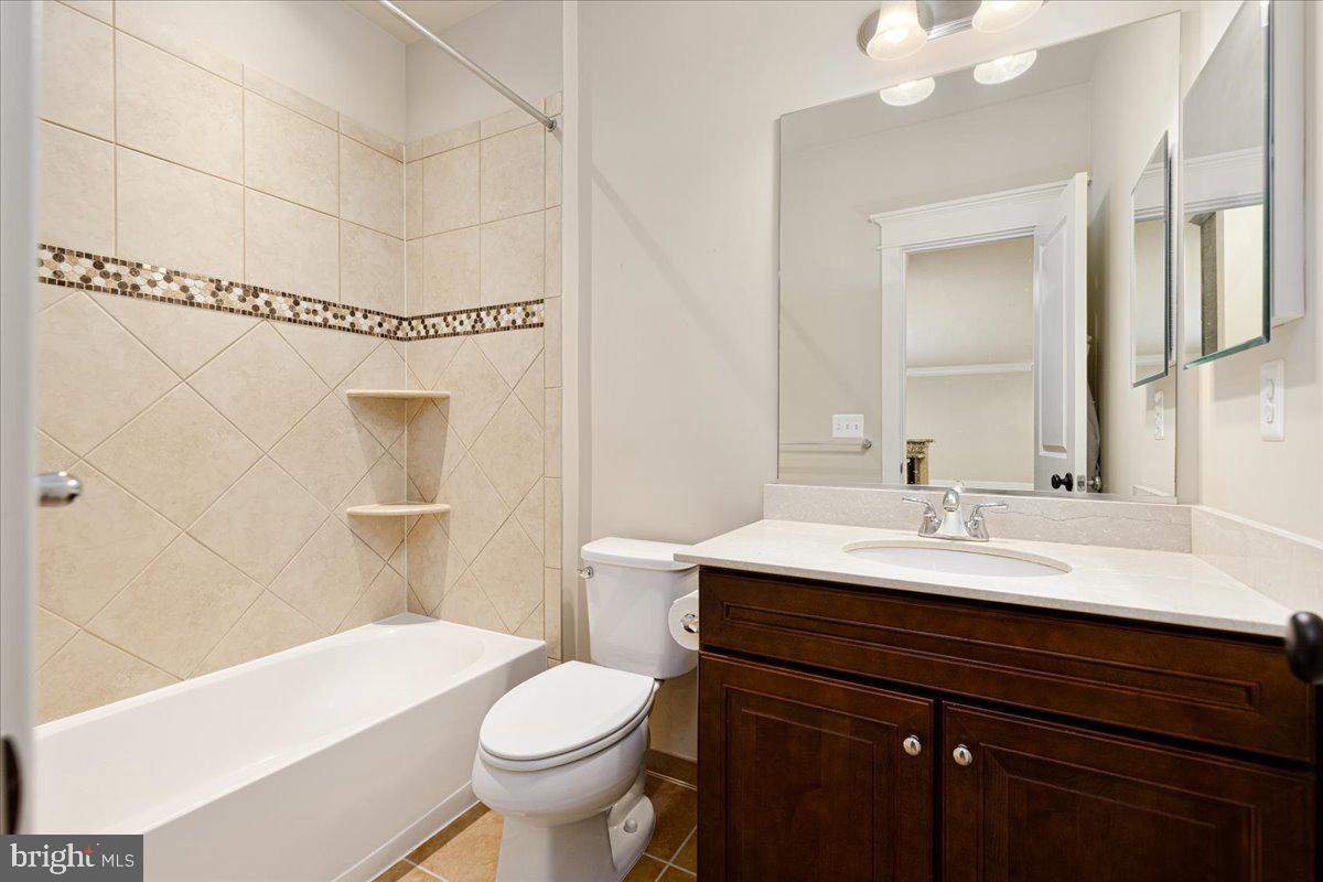 8104 Old Georgetown Road Bethesda, MD 20814 - Photo 26 of 28 a bathroom with a sink a toilet a mirror and shower