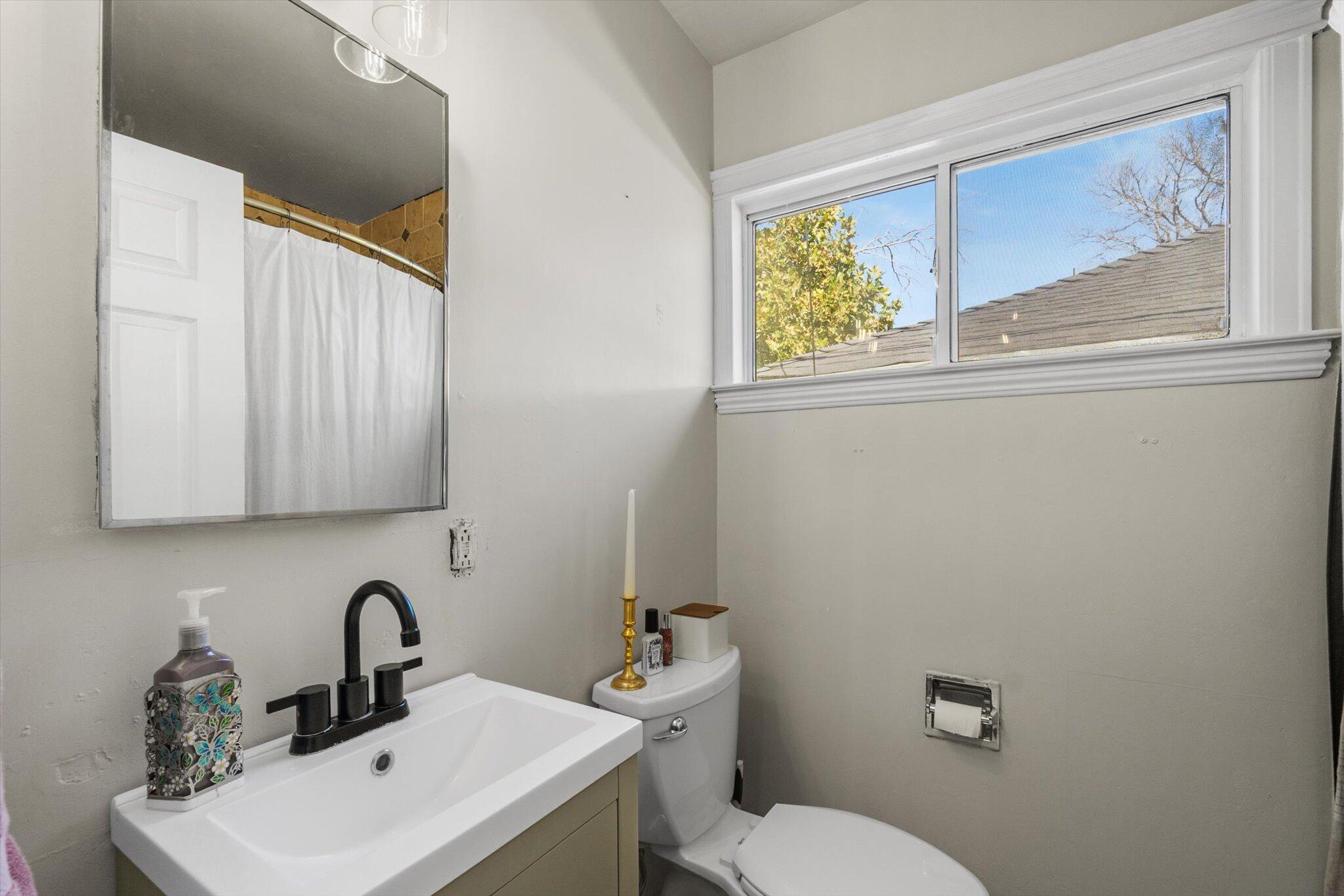 1514 Walbridge Street Red Bluff, CA 96080 - Photo 16 of 36 a bathroom with a toilet a sink and mirror