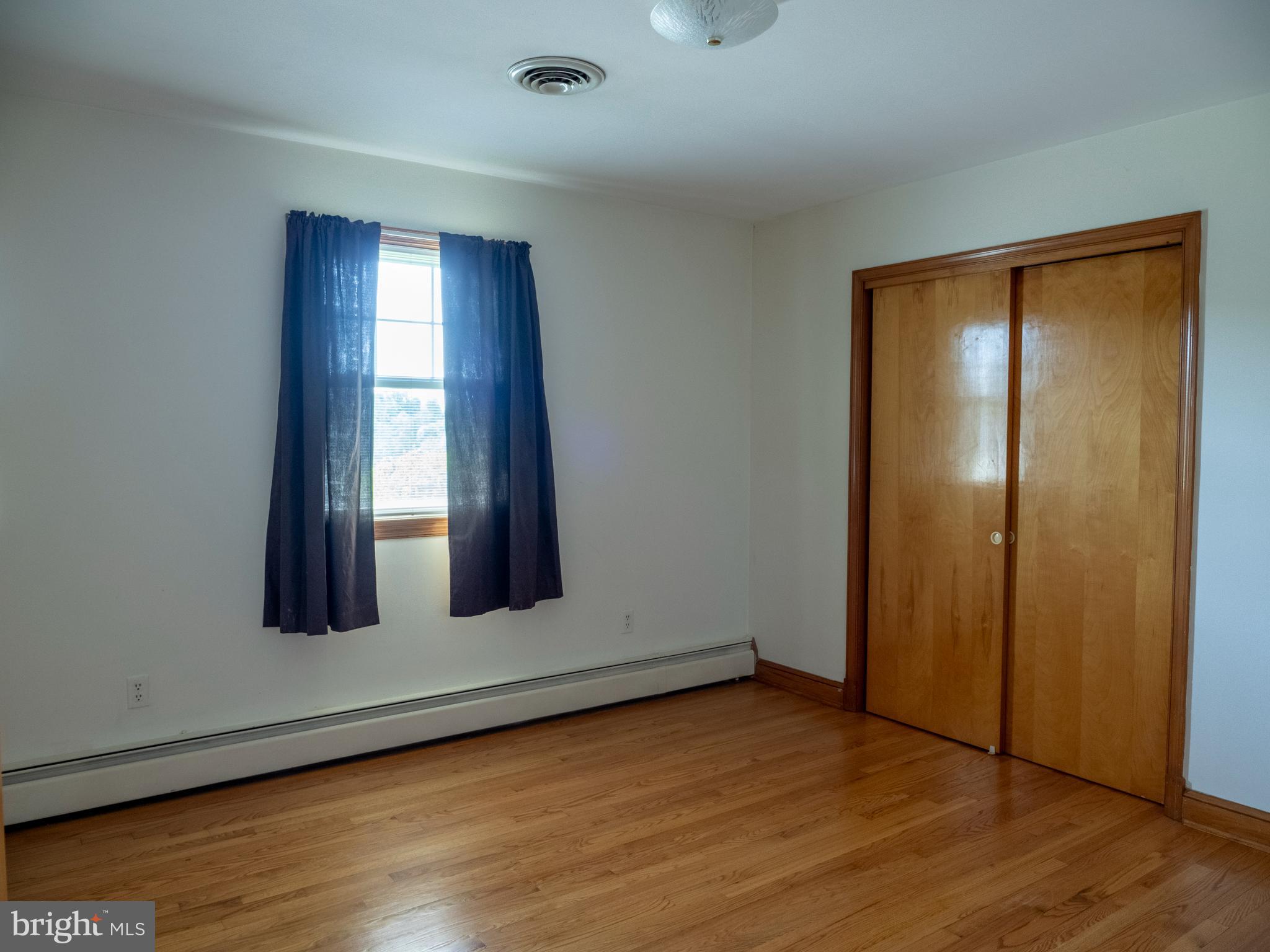 26906 Clarksburg Road Damascus, MD 20872 - Photo 10 of 17 an empty room with wooden floor and windows