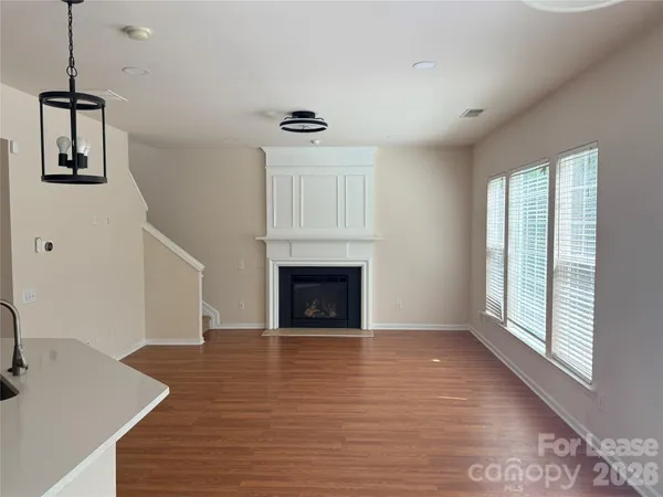 a view of a livingroom with wooden floor and a fireplace