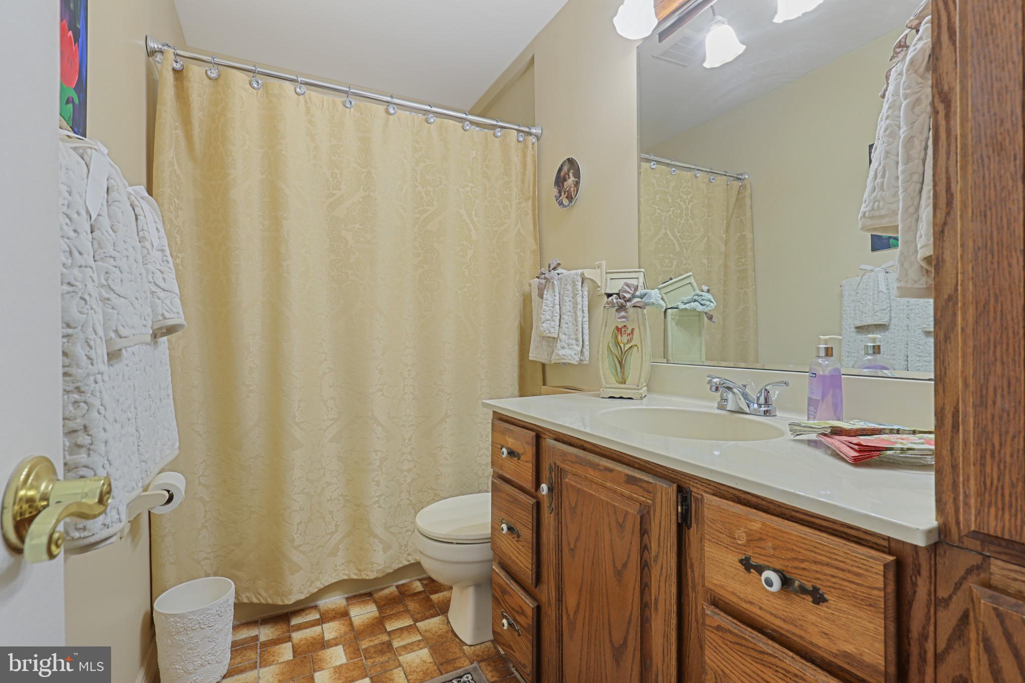 1300 Willow Road Dundalk, MD 21222 - Photo 29 of 36 a bathroom with a sink a toilet and shower curtain