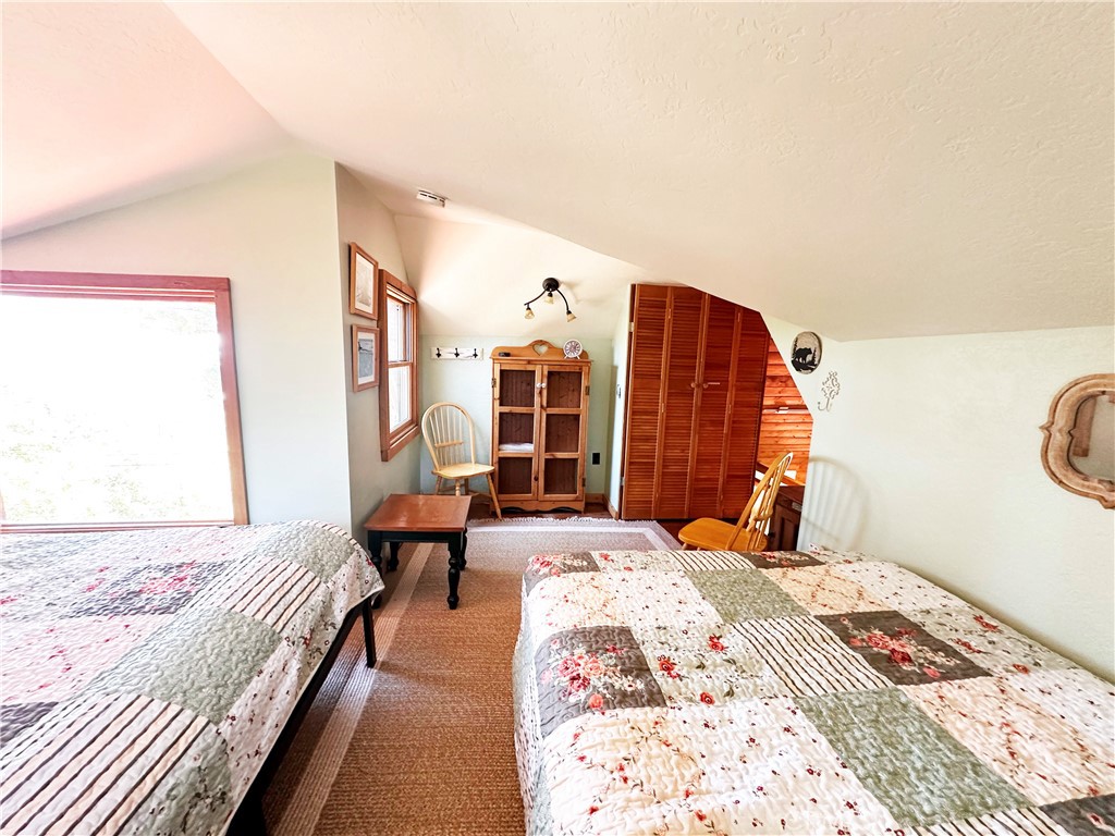 24387 Rocky Point Road Idyllwild, CA 92549 - Photo 11 of 29 a bedroom with a bed and a chandelier