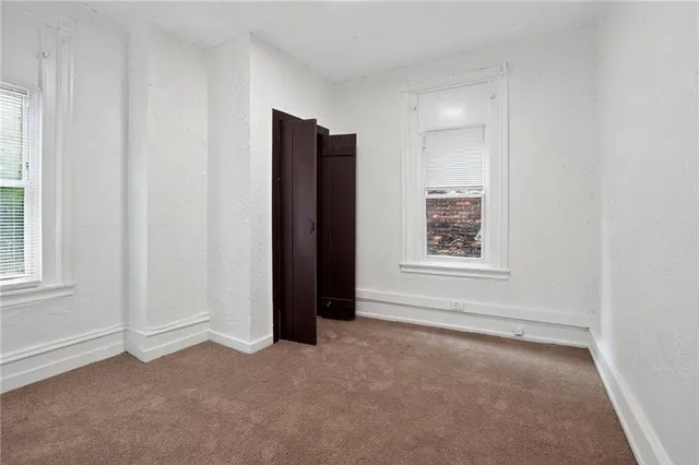 an empty room with windows and closet