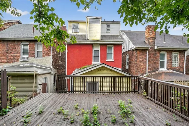 a view of wooden house and a small yard