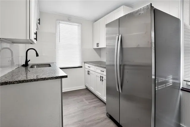 a kitchen with a refrigerator a sink and cabinets