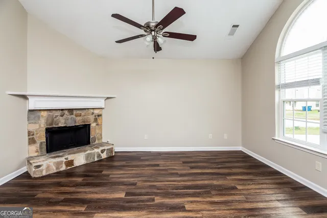 a living room with wooden floor and a fireplace