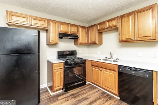 a kitchen with stainless steel appliances granite countertop a stove a sink dishwasher and a refrigerator