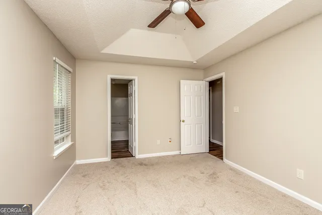 an empty room with closet and windows