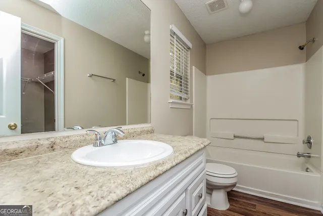 a bathroom with a granite countertop sink toilet and shower