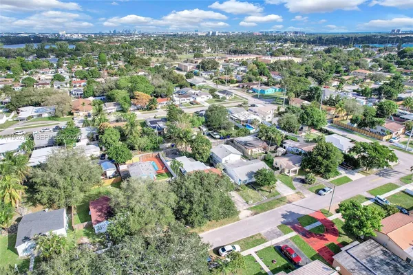 an aerial view of residential houses with outdoor space and trees