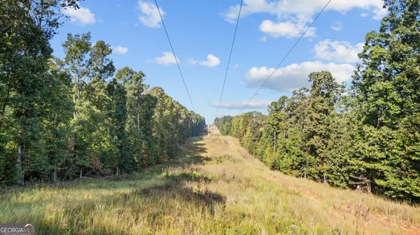 a view of a big house with a big yard and large trees