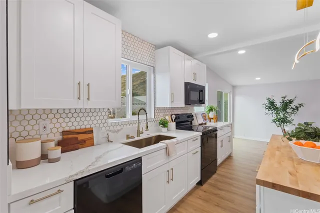 a kitchen with stainless steel appliances white cabinets sink and wooden floor