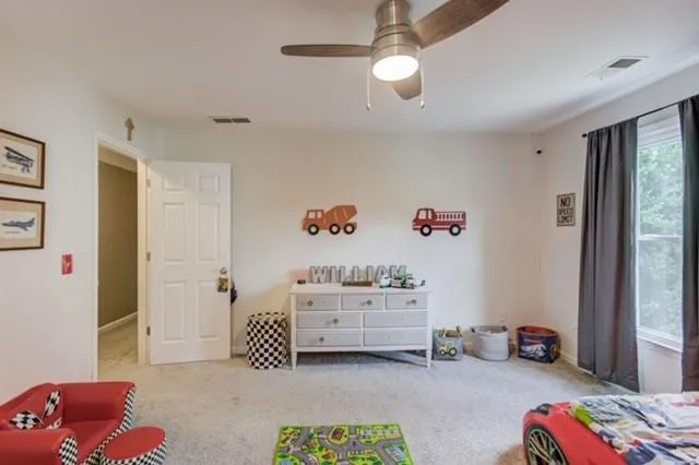 a bedroom with furniture and a chandelier fan