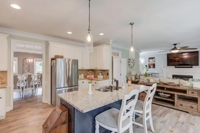 a kitchen with stainless steel appliances kitchen island granite countertop a dining table chairs and granite counter tops