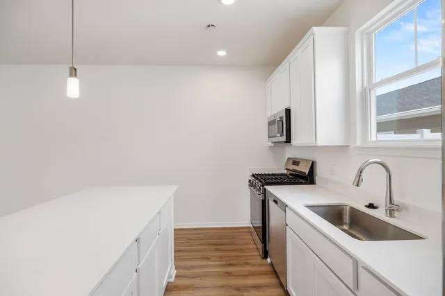 a kitchen with a sink a stove and cabinets