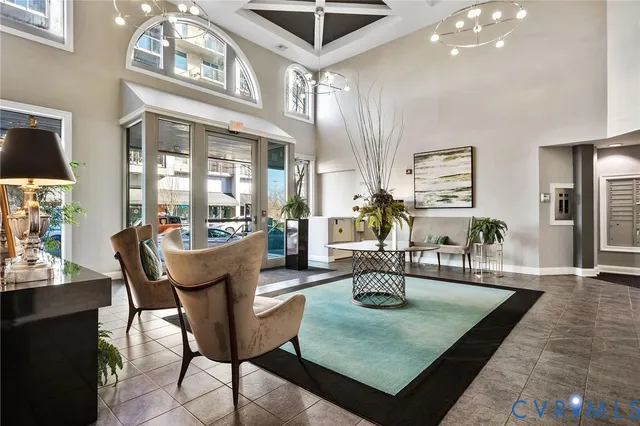 a living room with furniture a chandelier and a table
