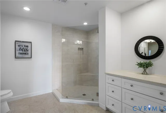 a bathroom with a granite countertop sink a toilet and a mirror