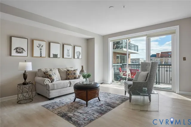 a living room with furniture potted plant and a large window