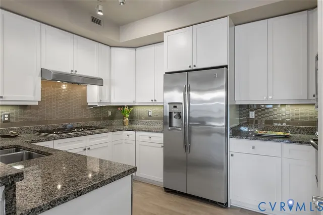 a kitchen with a refrigerator sink and cabinets