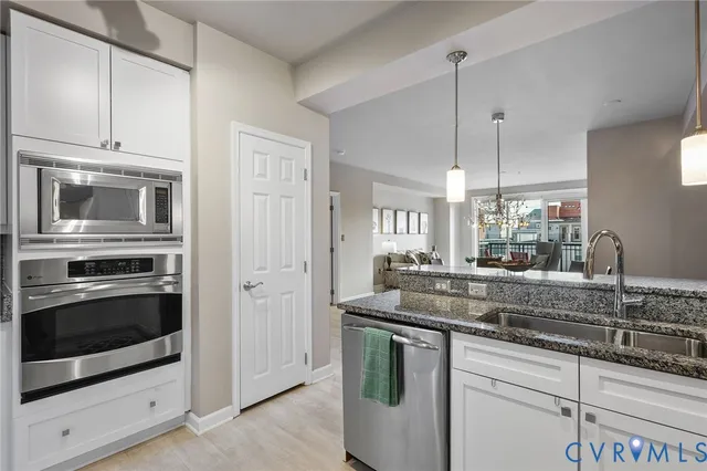 a kitchen with stainless steel appliances granite countertop a sink and a microwave