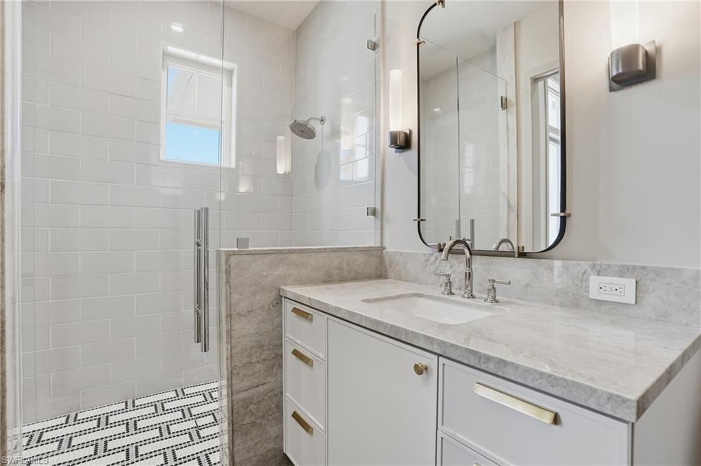 4851 Crayton Road Naples, FL 34103 - Photo 25 of 33 a bathroom with a sink and a mirror