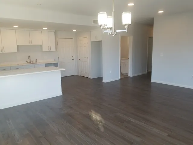 a view of a kitchen with wooden floor and a sink