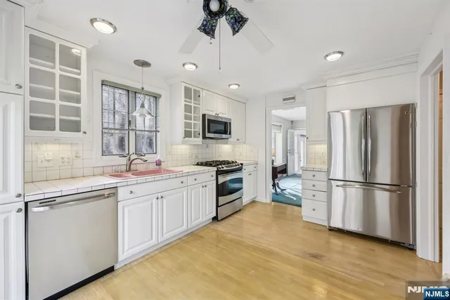 a kitchen with a sink stainless steel appliances and window