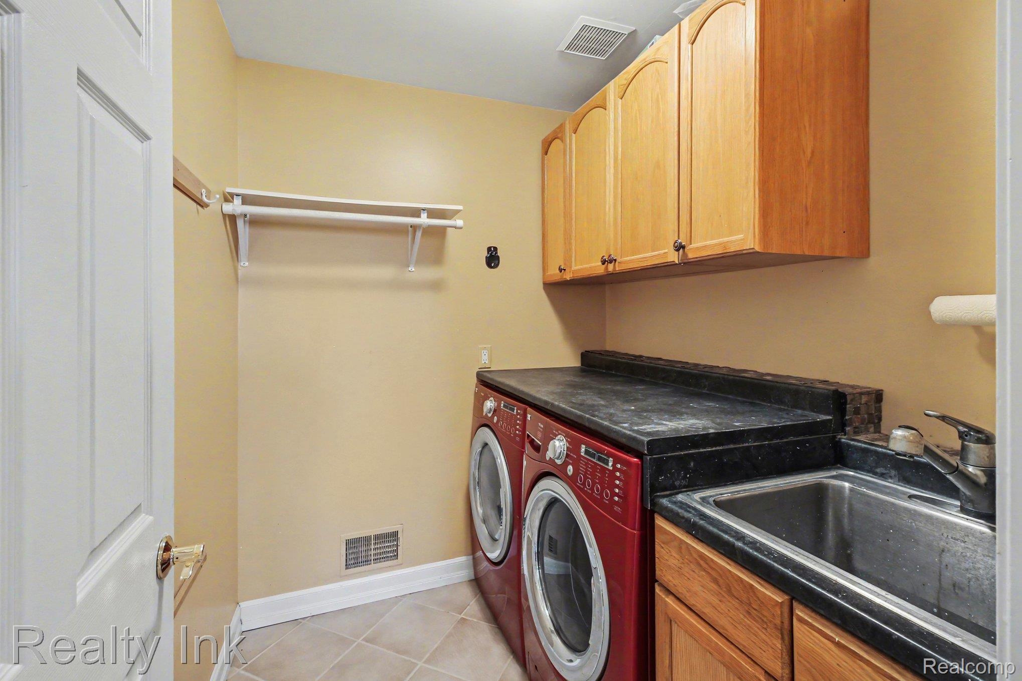 4927 Nature View Court Howell, MI 48843 - Photo 15 of 19 Laundry room featuring cabinet space, washer and clothes dryer, and light tile patterned flooring