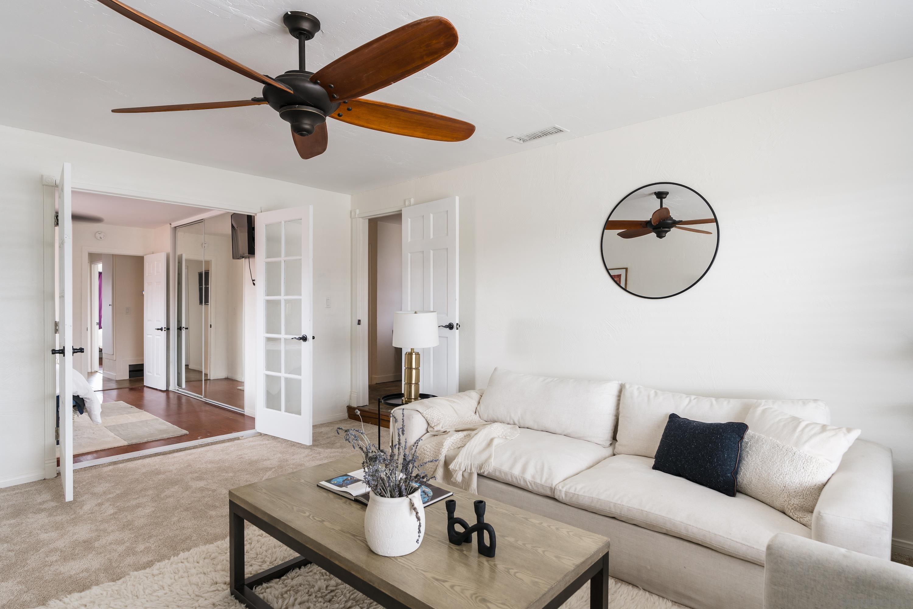 a living room with furniture a table and a fan