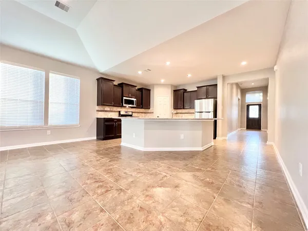 a kitchen with granite countertop a refrigerator and a sink