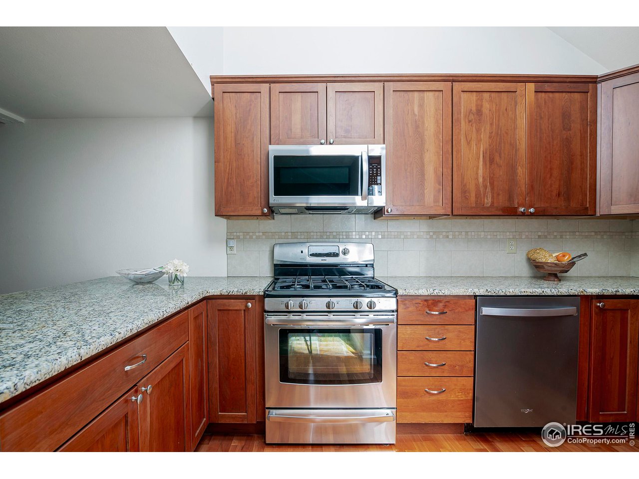 3054 Edison Court Boulder, CO 80301 - Photo 10 of 36 a kitchen with granite countertop a stove top oven microwave and cabinets
