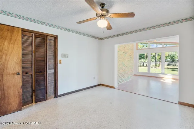 an empty room with closet and windows
