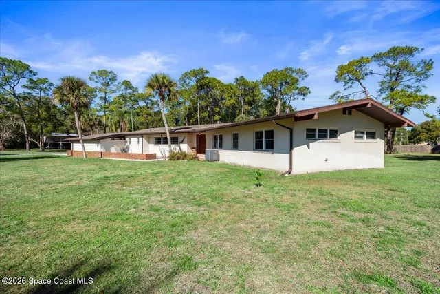 a view of a house with a backyard