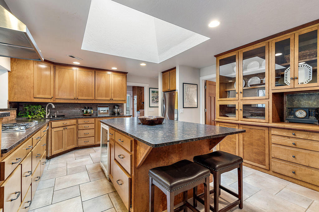 3828 Upper Applegate Road Jacksonville, OR 97530 - Photo 22 of 69 a kitchen with stainless steel appliances granite countertop a stove a sink dishwasher and a refrigerator with wooden cabinets