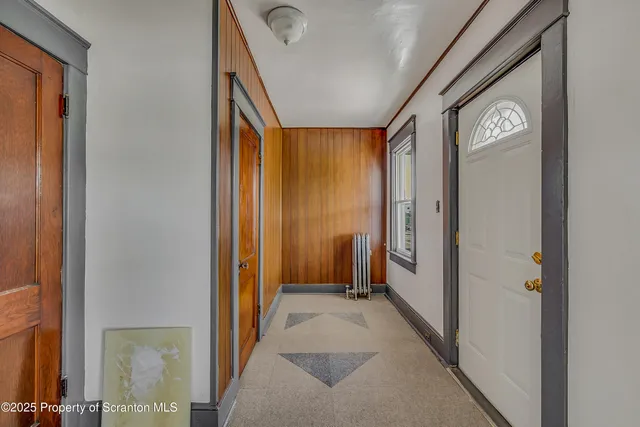 an empty room with windows and chandelier