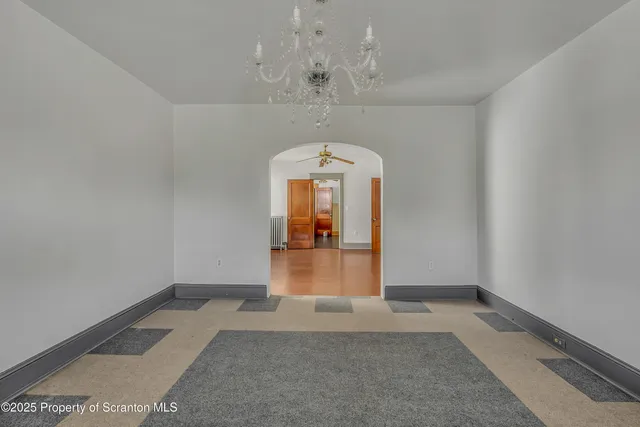 a view of a livingroom with wooden floor and a ceiling fan