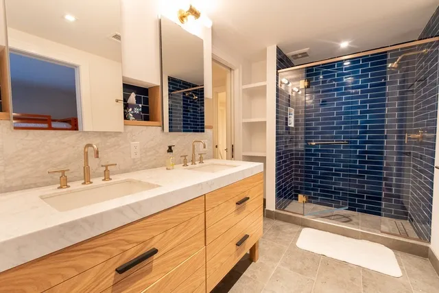 a bathroom with a granite countertop sink a large mirror and shower